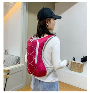 Detail shot of lightweight red outdoor sports backpack with bungee cord design and side zippers.