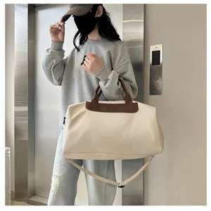 Large capacity travel duffel bag with brown leather handles, stylish gym luggage for short trips.