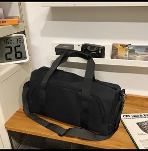 Detail shot of black sports duffel bag with shoulder strap and large capacity storage.