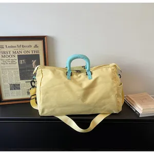 Grande borsa da viaggio sportiva gialla con manici azzurri e tracolla regolabile.