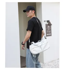 Detail view of the lightweight nylon sports travel duffel bag in white with shoulder strap.