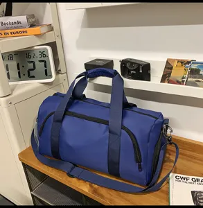 Detailed view of large capacity blue travel duffel bag with shoulder strap and multiple pockets.