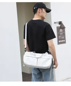 Detail shot of white nylon sports gym duffel bag with strap and logo patch for travel.