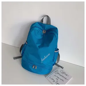 Detail view of blue oxford cloth sports backpack with dry wet separation and shoe pocket.