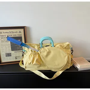 Dettaglio borsa da badminton gialla con tessuto in nylon resistente e tasca per racchetta blu.