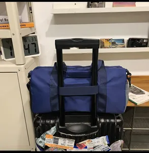 Large capacity blue travel duffel bag with trolley sleeve and shoe compartment for trips.
