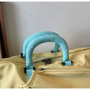 Primo piano del manico della borsa da viaggio resistente e dettagli della cerniera.