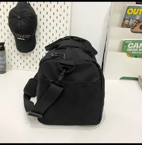 Black travel duffel bag with shoulder strap and mesh side pocket, perfect for gym and travel.