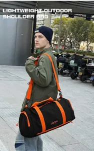 Outdoor gym travel duffel bag detail, black and orange color block design, sturdy strap.
