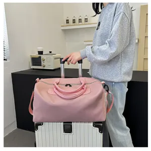 Close-up detail showcasing the spacious pink travel duffel bag with dual handles and straps.