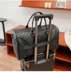 Detailaufnahme der schwarzen karierten Reisetasche mit weichem Leder und Trolley-Halterung.