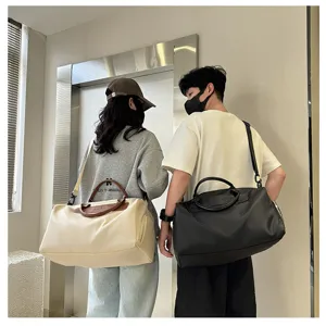 Detailed lifestyle shot of large capacity travel duffel bags with nylon fabric and leather handles.