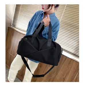Vue détaillée du grand sac de sport noir en tissu oxford avec poignées et bandoulière pratique.