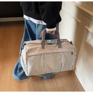 Detailed view of the large capacity travel sports gym bag with mesh front pocket and sturdy handles.