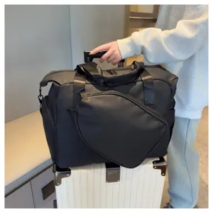 Vue détaillée du sac de sport noir montrant le tissu résistant et le compartiment spacieux.