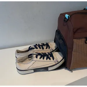 Detail view of large capacity travel gym bag with separate shoe compartment and canvas shoes.