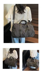Close-up view of the black travel duffel bag worn on shoulder, showing durable daily use.