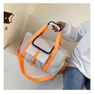 Vista detallada de la gran bolsa de deporte de viaje con correas naranjas y bolsillos prácticos.