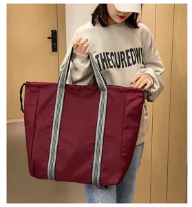 Large capacity oxford cloth travel luggage bag detail view in burgundy red color with dual straps.