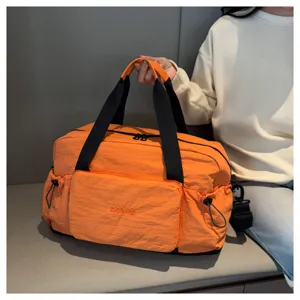 Grand sac de voyage pliable de grande capacite avec separation sec humide de couleur orange.