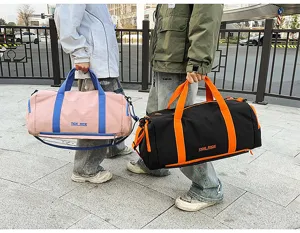 Detailed view of the color block travel duffel bag in street scene, showing dual handles.