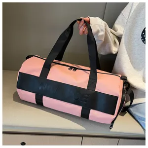 Detailed shot showing the pink fitness duffel bag featuring black handles and embossed logo.