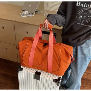 Orange travel duffel bag with pink straps, large fitness gym bag for outdoor travel sports.