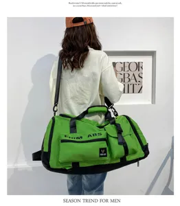 Detail view of the large capacity green travel duffel bag with multiple pockets and shoulder strap.