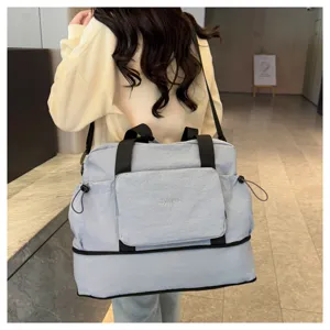 Grand sac de voyage pliable bleu clair avec des bretelles noires et une poche avant.