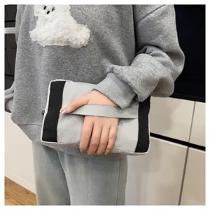 Vue de détail d'un sac de voyage gris pliable en tissu résistant avec des poignées solides.