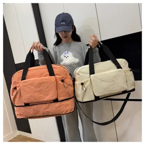 Vue détaillée du grand sac de voyage pliable avec poche avant et poignées résistantes.