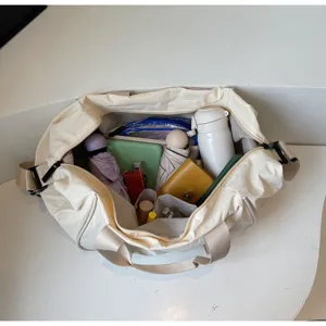 Detail view of the beige oxford yoga travel duffel bag showing interior storage capacity.