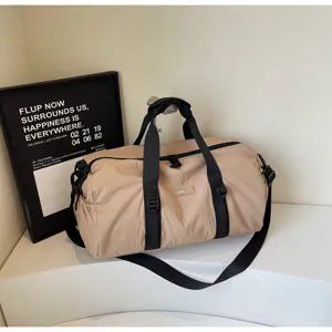Detail view of khaki travel duffel gym bag with sturdy black straps and waterproof fabric.