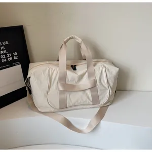 Detail of beige travel duffel bag showing durable fabric, sturdy handles and zipper for gym.