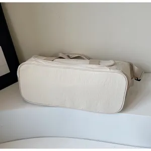 Detail view of the lightweight beige fitness travel bag, showing durable nylon fabric and fine stitching.