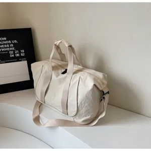 Close-up detail of the beige gym duffle bag showing durable fabric and sturdy buckle.