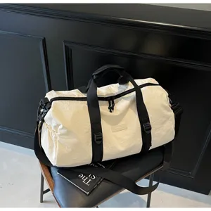 Detail shot of minimalist white travel duffle bag with black straps, waterproof gym sports shoulder bag.