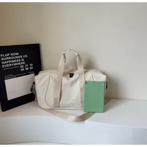 Minimalist beige canvas travel duffel bag with handles for yoga gym and outdoor sports.