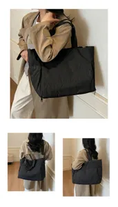 Detailed view of large capacity black tote bag with shoulder strap and side zipper pocket.