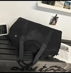 Detailed view of large capacity black gym duffel bag with zipper compartments for travel.