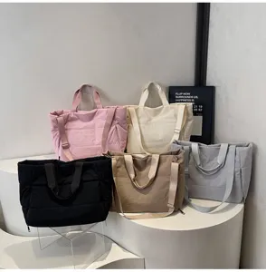 Detailed view of minimalist puffer tote bag, large capacity quilted shoulder bag for women.