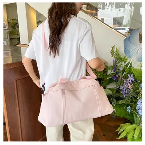 Vista dettagliata della grande borsa da viaggio rosa con tracolla per sport e yoga.