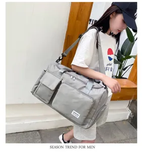 Large capacity gray travel duffel bag with shoe compartment and multiple pockets for gym.
