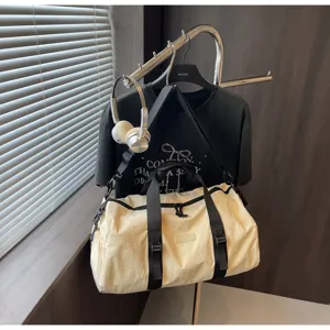 Cream white casual travel duffel bag with black straps and waterproof fabric for daily use.