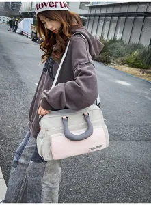 Detail view of the travel duffel bag showing its two-tone grey and pink color block design.