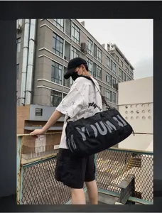 Grand sac de sport noir pour le fitness, l'entraînement et les voyages avec sangle.