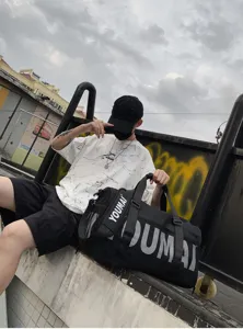 Vue détaillée du grand sac de sport noir avec compartment chaussures et impression de lettres.