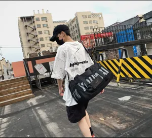 Grand sac de sport de fitness et de voyage étanche avec un design élégant à imprimé de lettres.