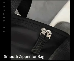 Gros plan sur la fermeture éclair métallique lisse et le tissu durable du sac de sport noir.