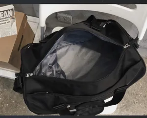 Détail de sac de voyage sport noir, avec séparation humide sèche et compartiment chaussures.